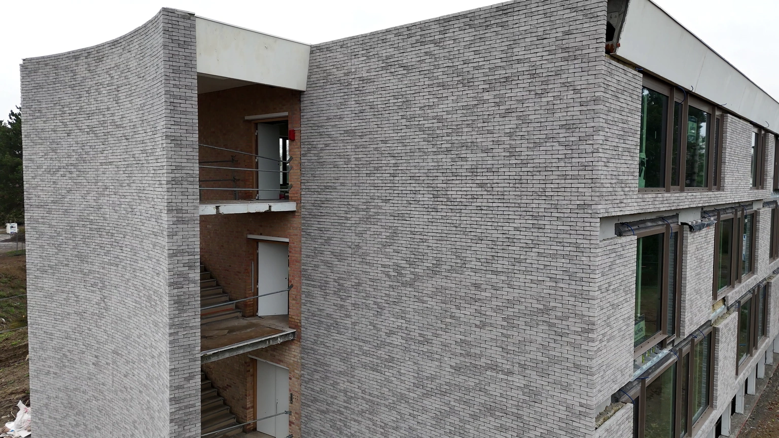 Angle d’une façade en briques grises du projet Wasqual